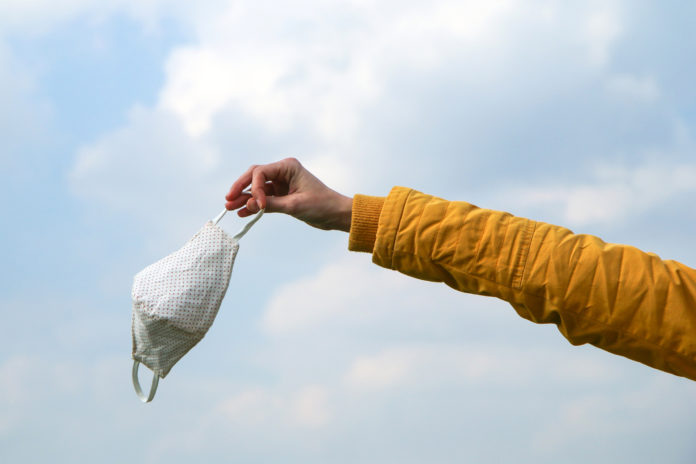 Woman is holding the textile home made face mask